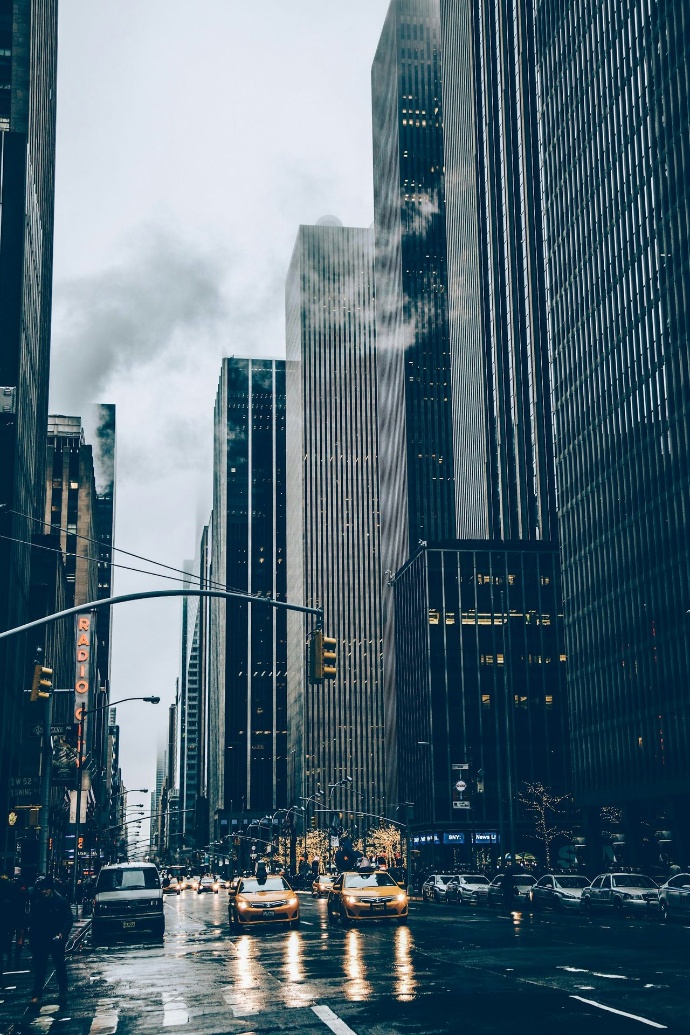 two yellow cars besides concrete buildings